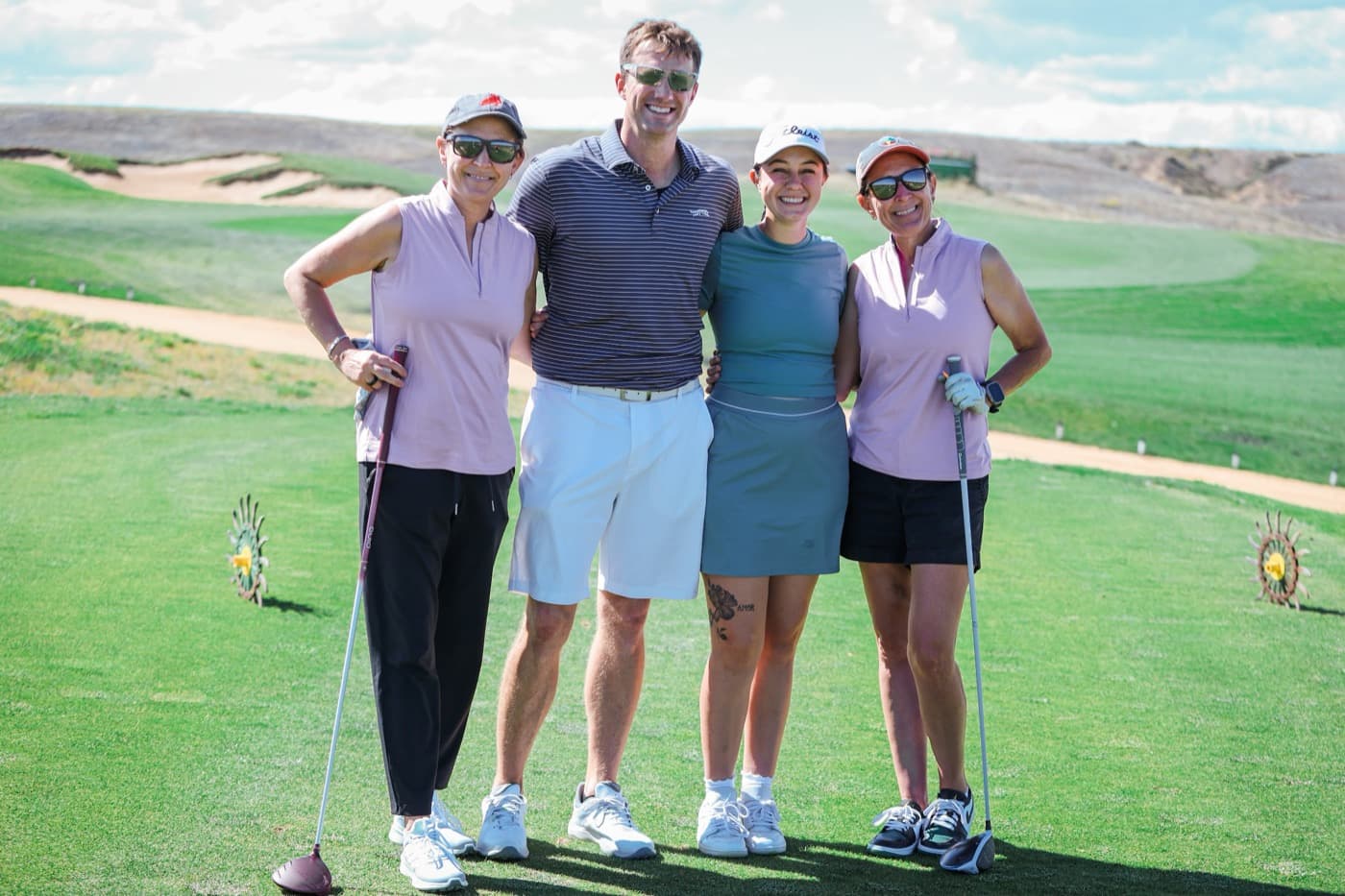 A foursome smiling on the fairway